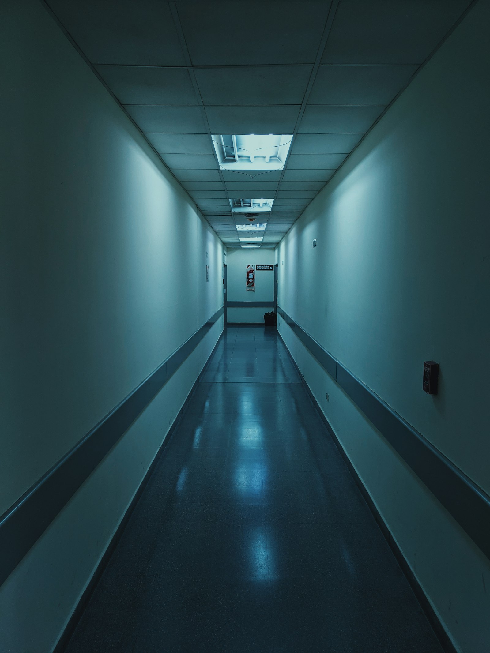 A cool blue-lit hospital corridor